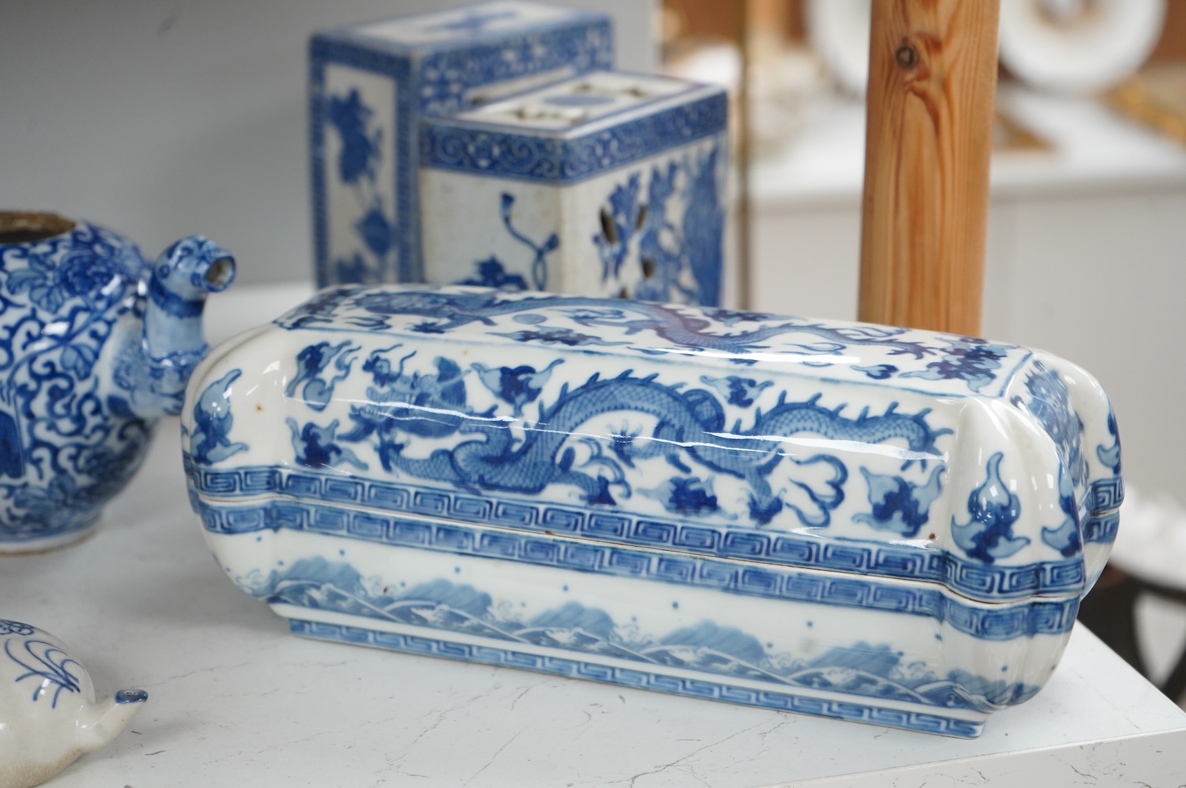 A group of Chinese blue and white comprising a dish and cover, two pillows, waterdropper and a teapot, largest 26cm wide
